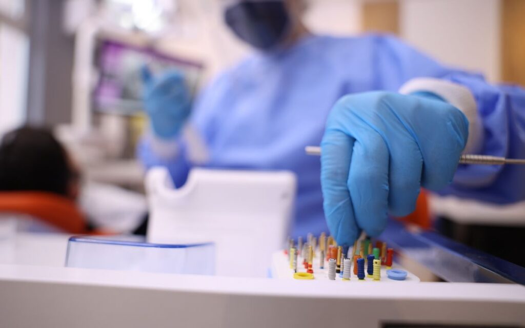 Close-up of dentist with gloves preparing dental tools for patient operation in modern clinic.