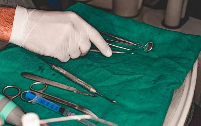 Close-up of dental tools on a green cloth prepared for a medical procedure.