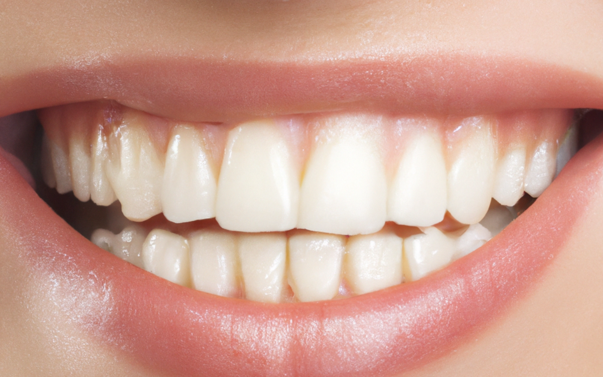 A detailed close-up of a perfect set of white teeth and lips in a bright smile.