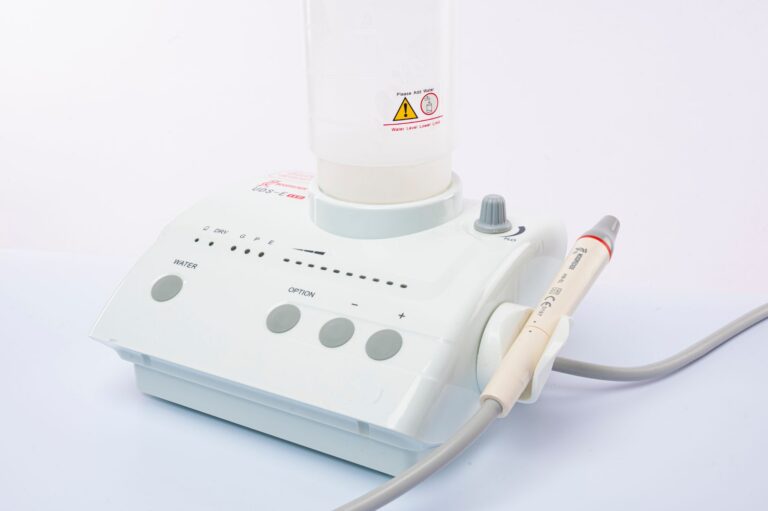Close-up of a dental ultrasonic scaler with water supply on a white background.