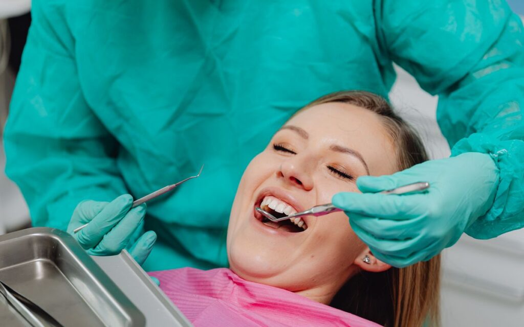 A happy woman receiving a dental examination, showing confidence in professional oral care.