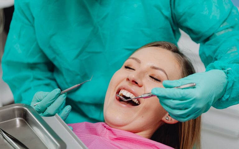 A happy woman receiving a dental examination, showing confidence in professional oral care.
