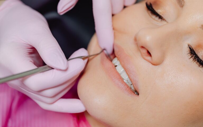 Close-up of a dental checkup showing tools and patient's mouth with a blurred background.