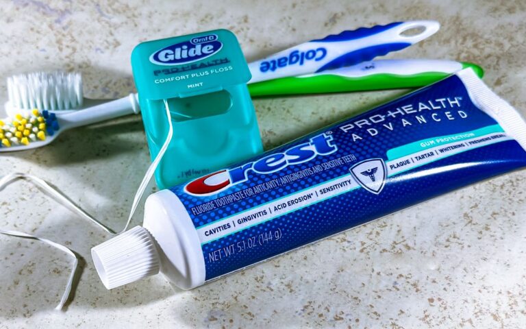 Close-up of dental care items including toothbrush, floss, and toothpaste for oral hygiene.