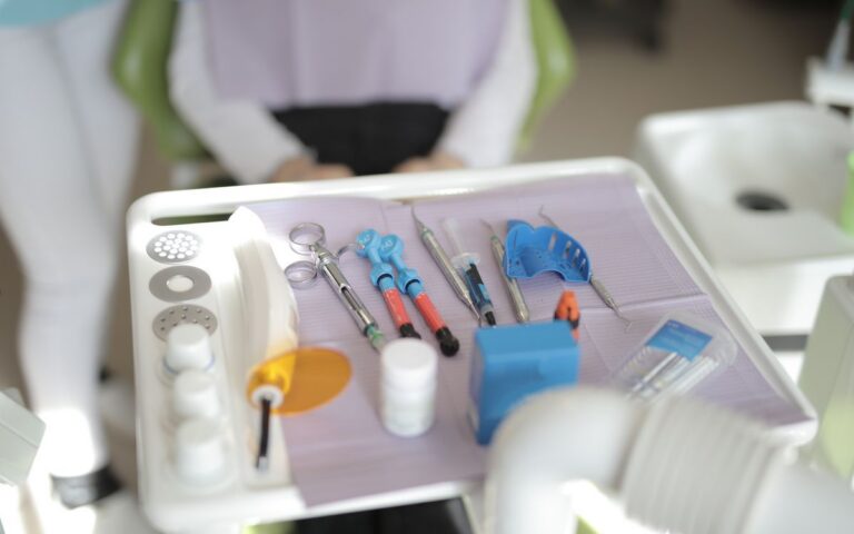 From above view of various modern medical instruments placed on tray near chair in modern room in clinic