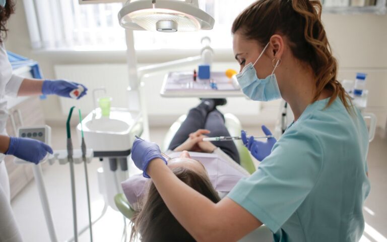 A female dentist performs dental treatment on a patient in a modern clinic.