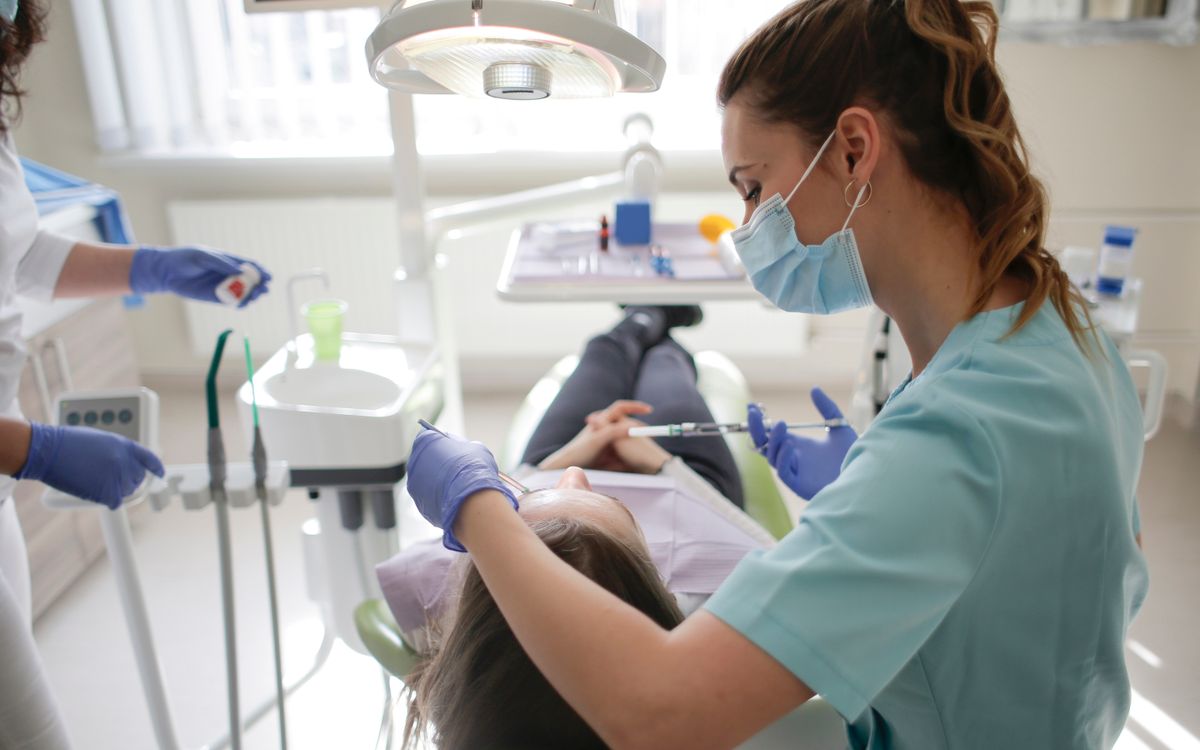 A female dentist performs dental treatment on a patient in a modern clinic.