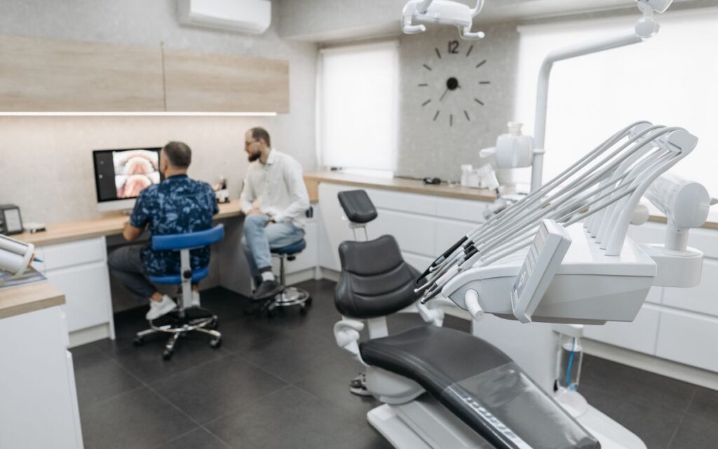 Dental professionals discussing patient images in a modern clinic setting.