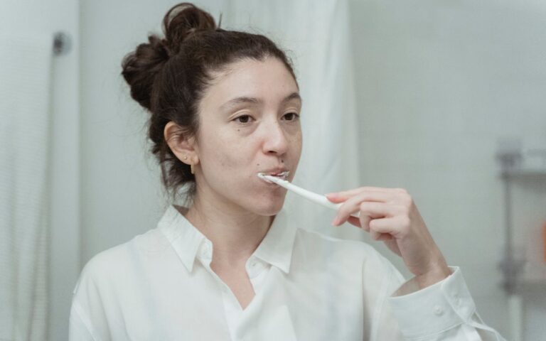 Young woman practicing dental hygiene by brushing her teeth in the morning.