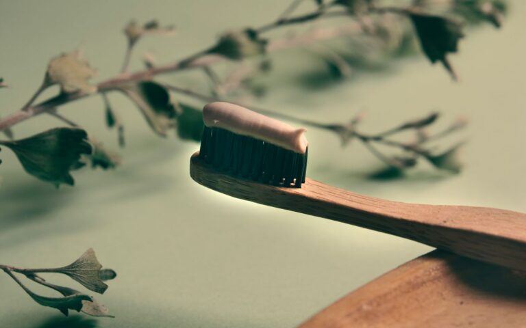 A close-up of a wooden toothbrush with toothpaste, highlighting eco-friendly dental care.