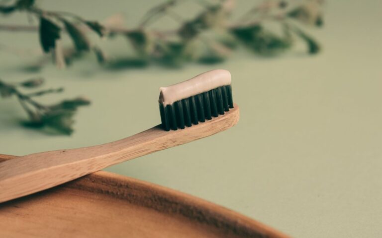 Close-up of a bamboo toothbrush with toothpaste for sustainable and eco-friendly oral hygiene.