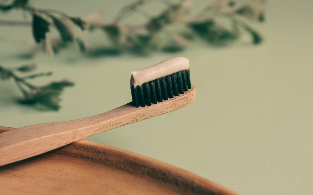 Close-up of a bamboo toothbrush with toothpaste for sustainable and eco-friendly oral hygiene.